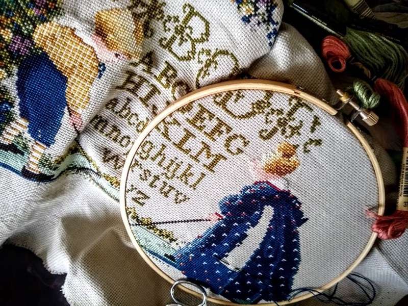 Vintage cross-stitch sampler with alphabet and children scene